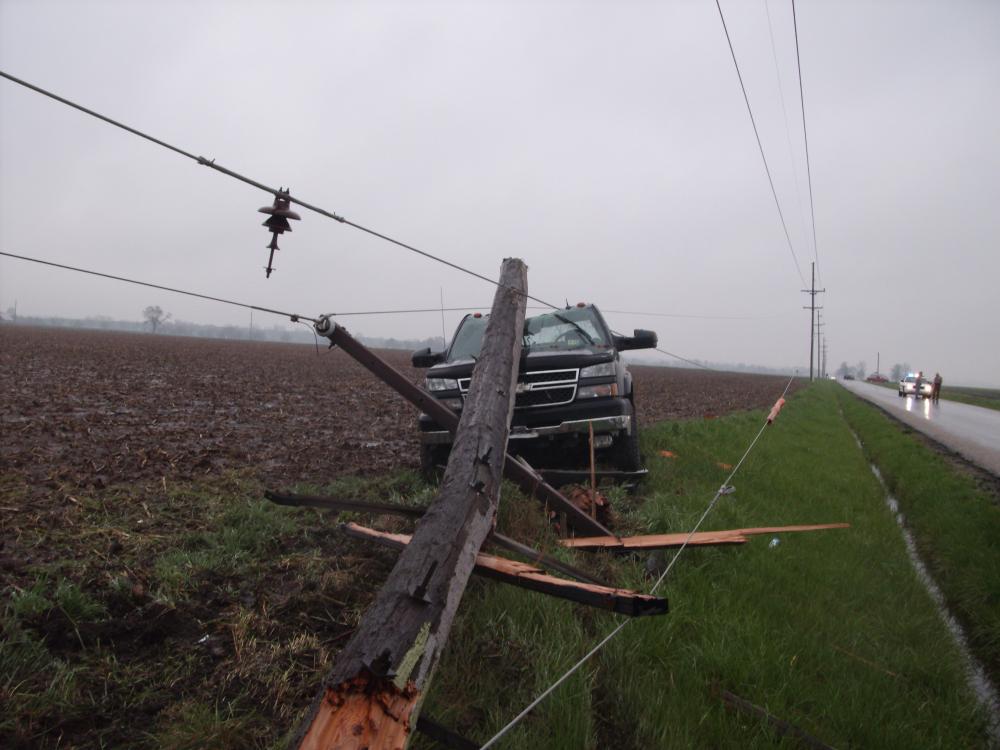 Image of vehicle accident involving breaking a pole, pulling lines down