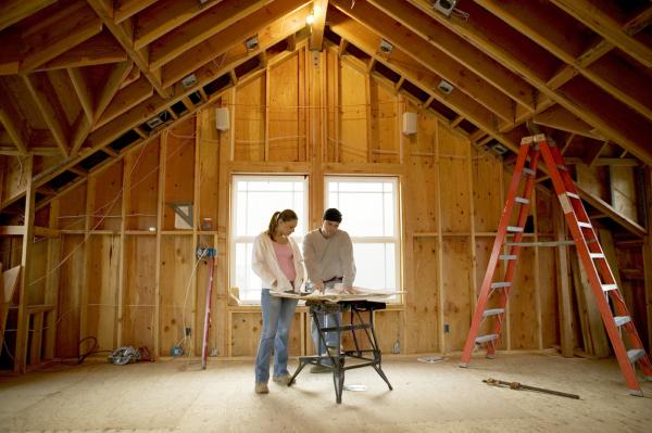 Couple standing in attic under construction
