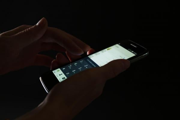 Image of person holding cell phone in the dark