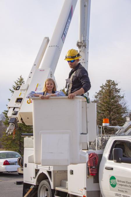 Image of girl in bucket with lineworker