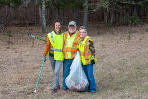Three volunteers cleaning up roadside ditches near Lake Bemidji State Park