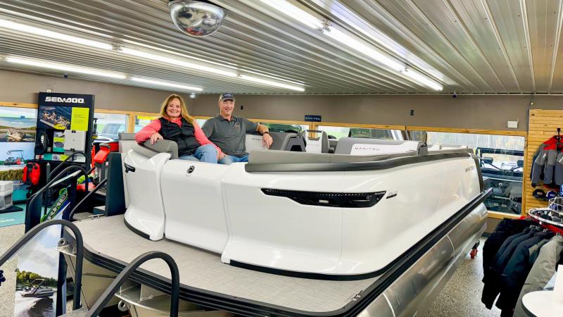 Owners Mary Jo and Doug Wolter sitting in pontoon in showroom