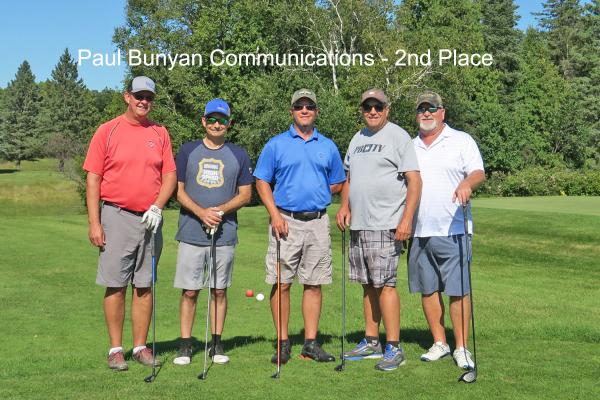 2nd place team, Paul Bunyan Communications on golf course with golf clubs