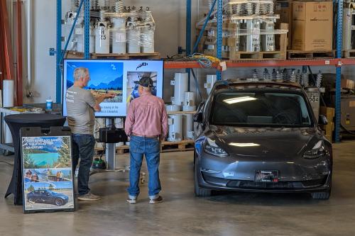 Bob Gregg visits with an attendee about his trip from Bemidji to Banff, Canada in his Tesla