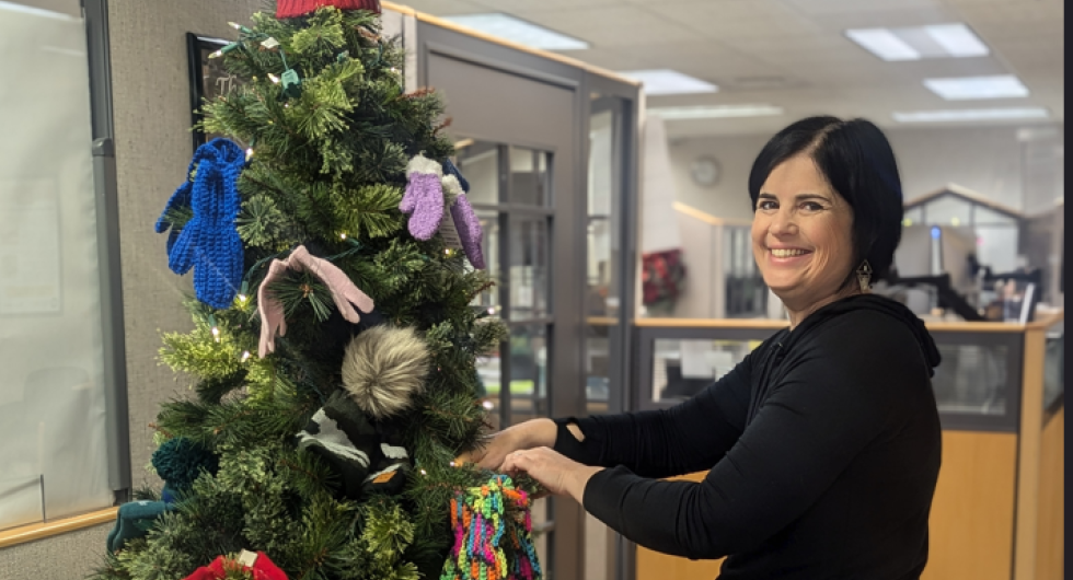 BEC receptionist, Kathy, puts mittens on a tree
